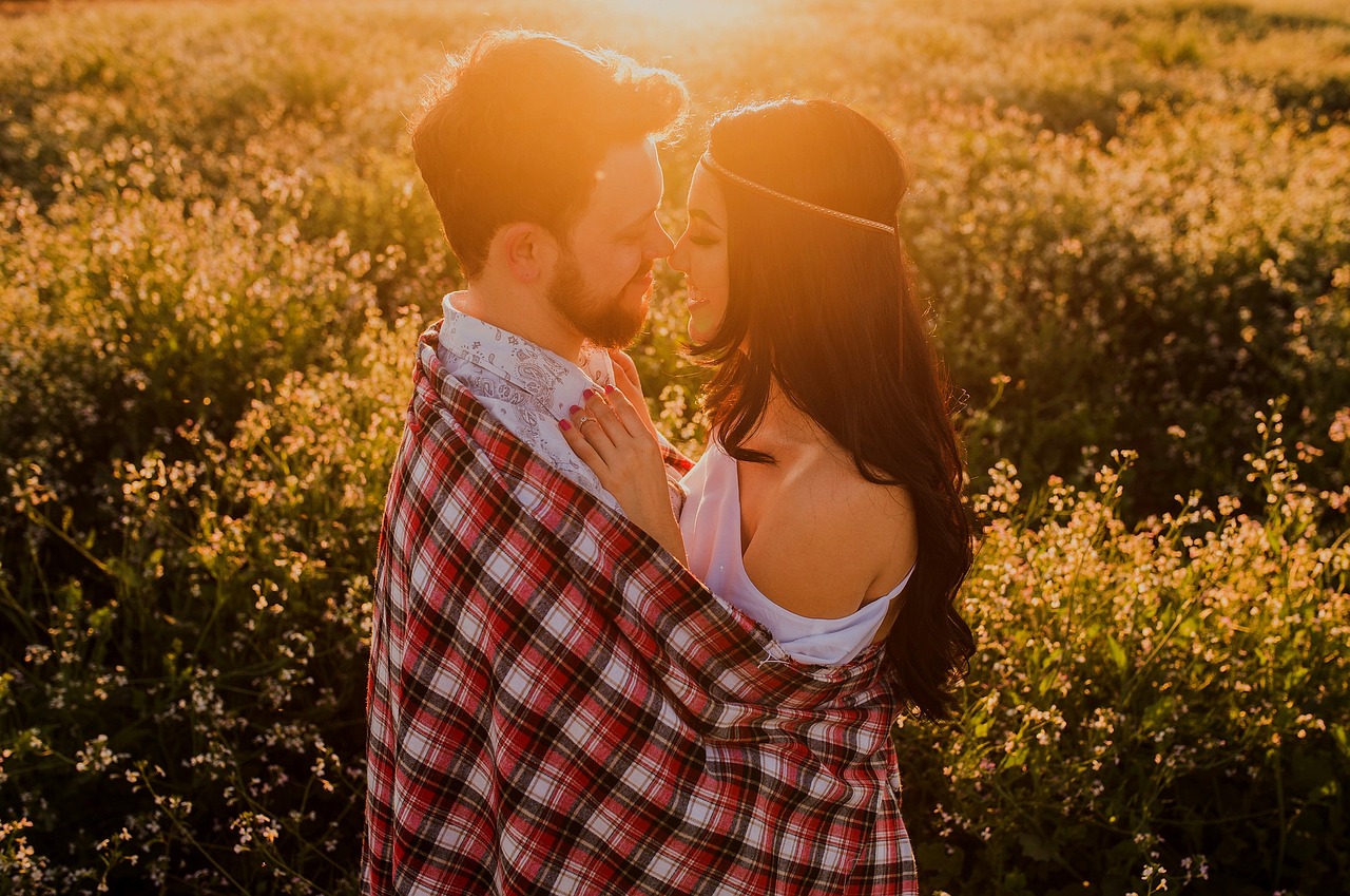 Couple amoureux dans un champ de fleurs au coucher du soleil — SayLove Agency, agence matrimoniale Lille
